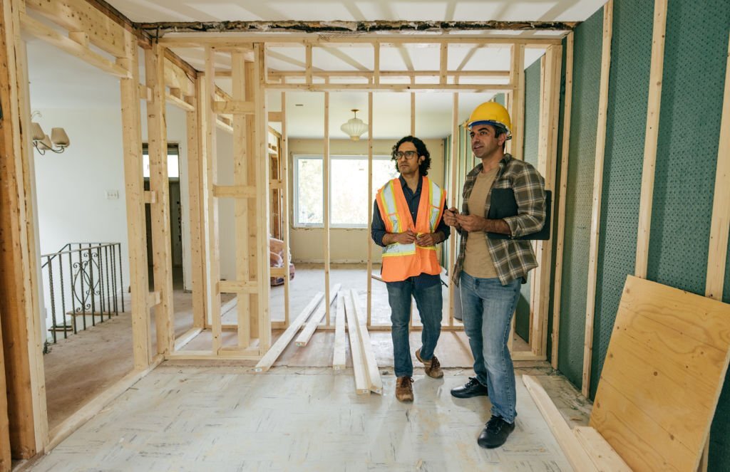 Construction worker is showing to project manager completed design on construction site.