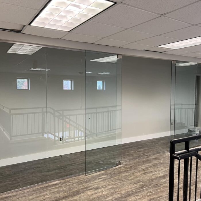 A remodeled commercial office with glass walls and wood flooring