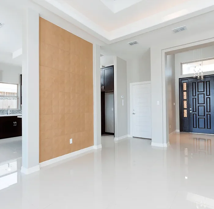 A remodeled entryway for a home with white marble floors and a dark colored door
